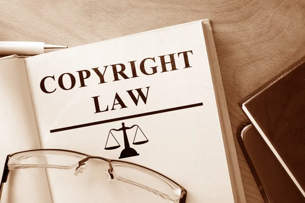 Copyright law book with glasses and a pen